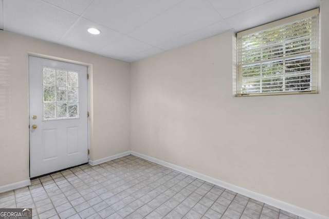 doorway with a paneled ceiling, plenty of natural light, baseboards, and recessed lighting