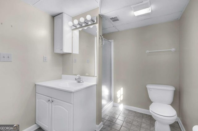 full bathroom with a stall shower, baseboards, toilet, vanity, and a paneled ceiling