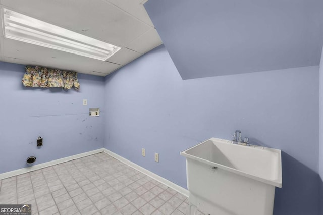 laundry area featuring laundry area, baseboards, tile patterned floors, washer hookup, and a sink