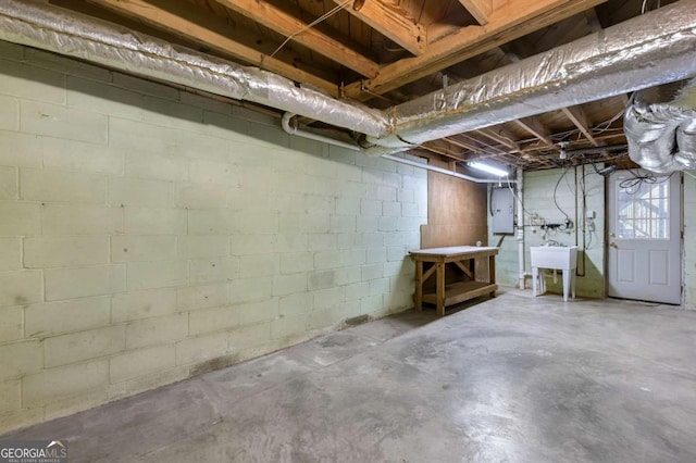 unfinished basement featuring electric panel and a sink