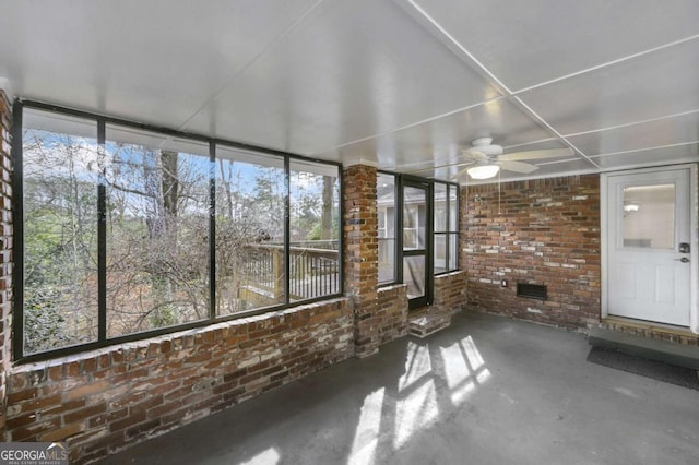 unfurnished sunroom with ceiling fan