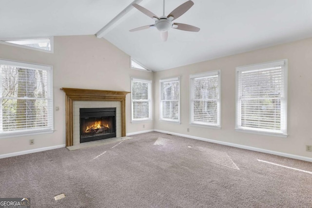 unfurnished living room featuring lofted ceiling with beams, a tiled fireplace, carpet flooring, and baseboards