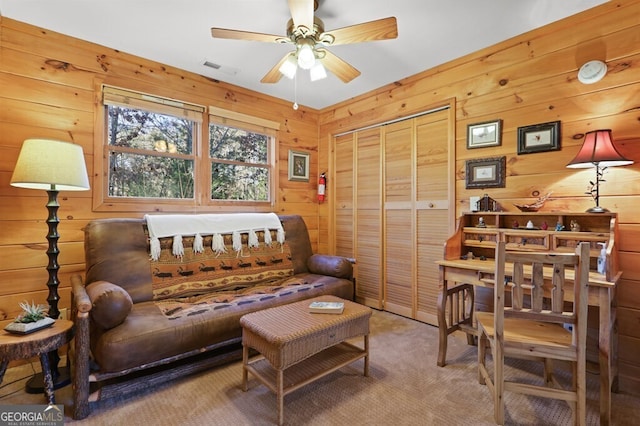 interior space featuring ceiling fan and wood walls