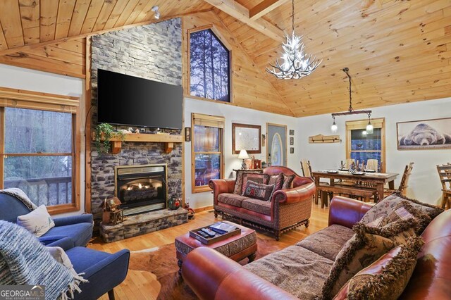 living room featuring wooden ceiling, a fireplace, a notable chandelier, and wood finished floors