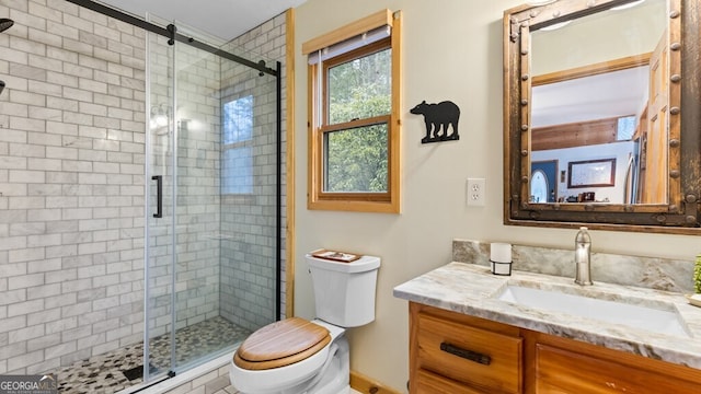 full bath with vanity, a shower stall, and toilet