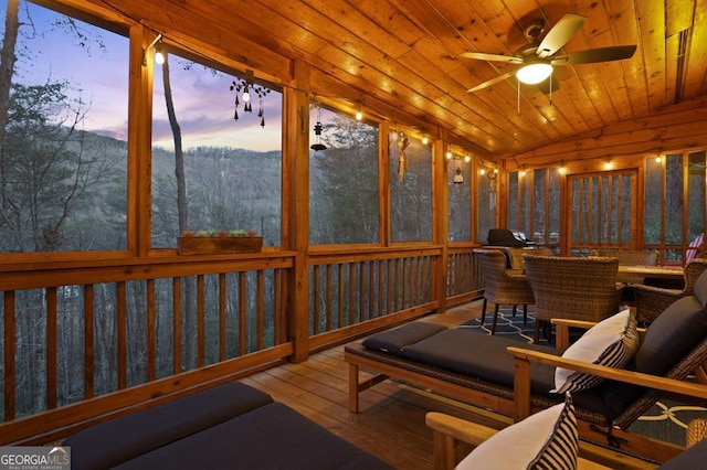 sunroom / solarium with lofted ceiling, ceiling fan, and wooden ceiling