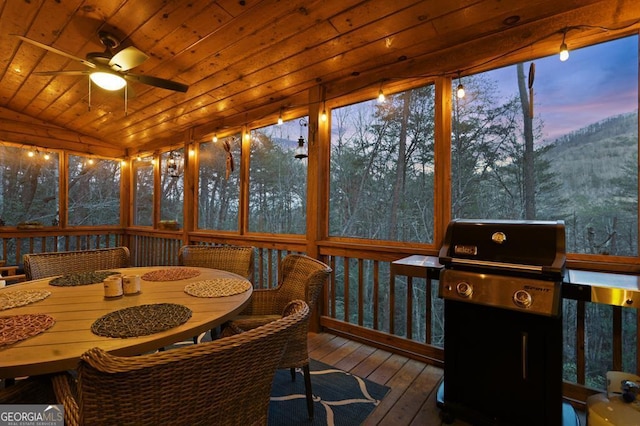 sunroom / solarium featuring wooden ceiling, vaulted ceiling, and ceiling fan