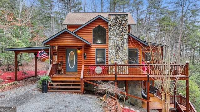 view of front of house with a shingled roof, stone siding, and a deck