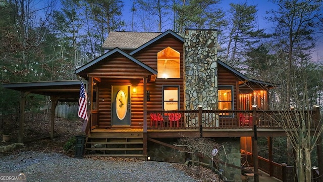 log-style house featuring a chimney, a shingled roof, log veneer siding, and a porch