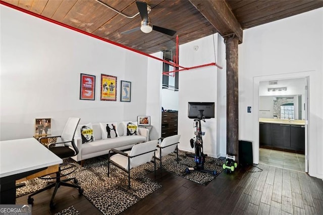 living room featuring dark wood-type flooring, wooden ceiling, and decorative columns