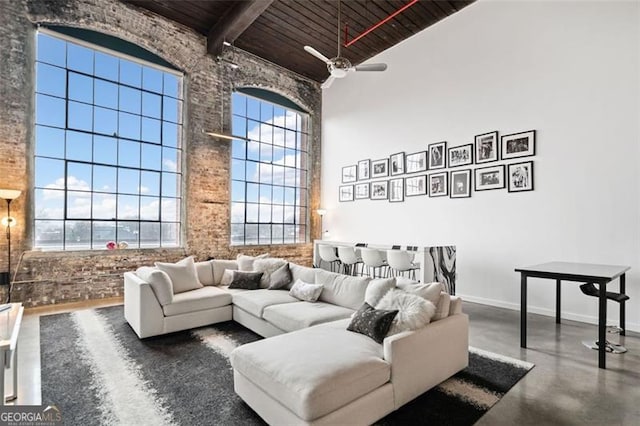 living room with wooden ceiling, concrete floors, a healthy amount of sunlight, and a high ceiling