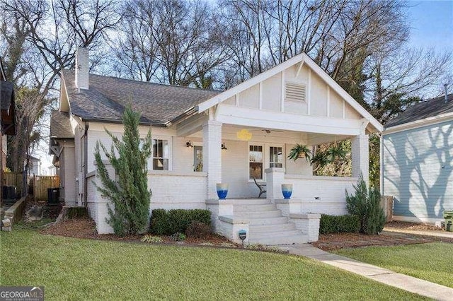 view of front of property featuring central AC, a porch, and a front yard