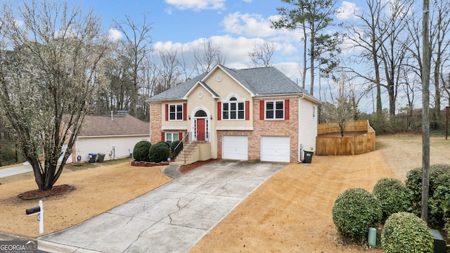 split foyer home featuring brick siding, roof with shingles, central air condition unit, concrete driveway, and an attached garage