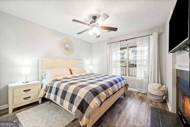 3655 Habersham Rd Unit B129, Atlanta, GA 30305 - bedroom with dark hardwood / wood-style floors, ceiling fan, a fireplace, and a textured ceiling