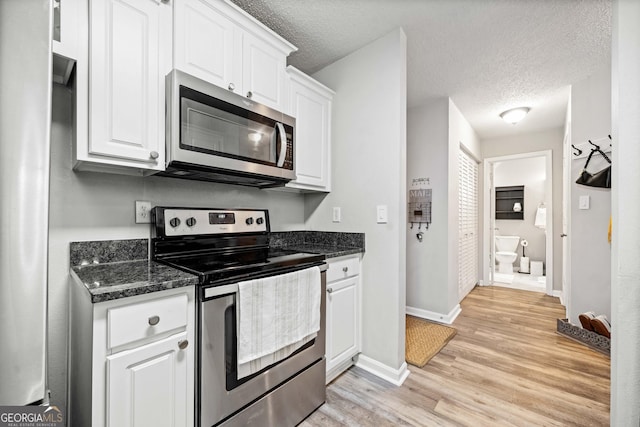 3655 Habersham Rd Unit B129, Atlanta, GA 30305 - kitchen featuring stainless steel appliances, light wood-type flooring, a textured ceiling, and white cabinets