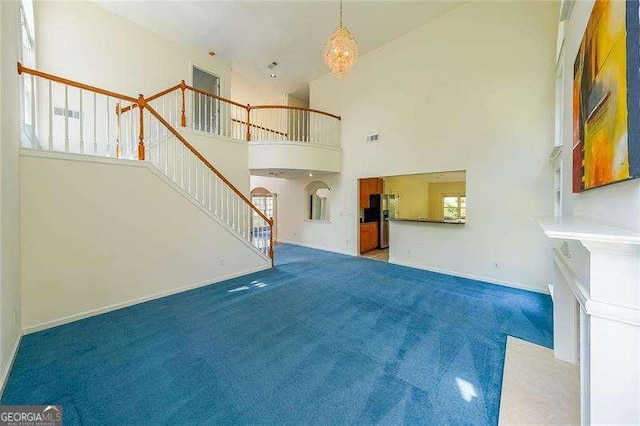 unfurnished living room with carpet and high vaulted ceiling