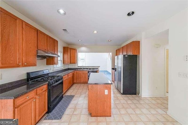 kitchen featuring sink, stainless steel fridge with ice dispenser, a kitchen island, and black gas range oven