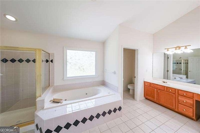 full bathroom featuring vaulted ceiling, shower with separate bathtub, tile patterned flooring, vanity, and toilet