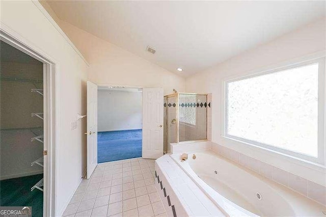 bathroom with tile patterned flooring, lofted ceiling, and independent shower and bath