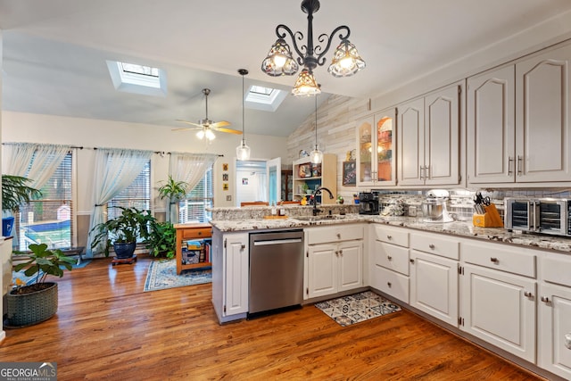 kitchen with white cabinetry, pendant lighting, stainless steel dishwasher, and kitchen peninsula