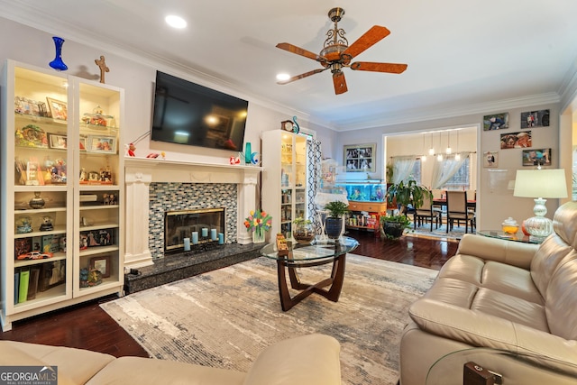 living room featuring hardwood / wood-style floors, crown molding, a fireplace, and ceiling fan