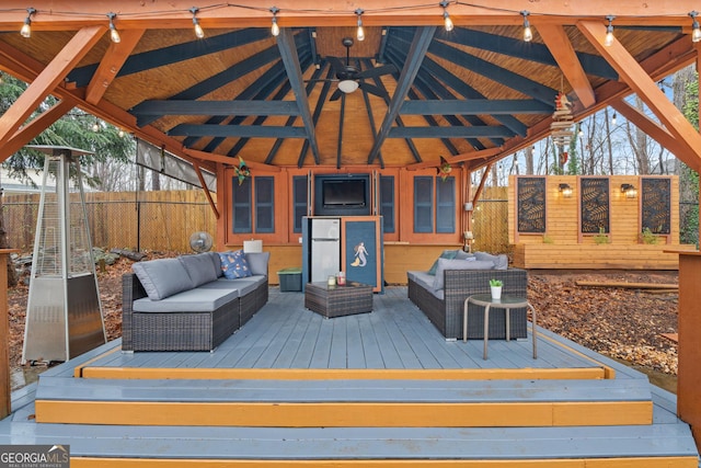 wooden deck with a gazebo, outdoor lounge area, and ceiling fan