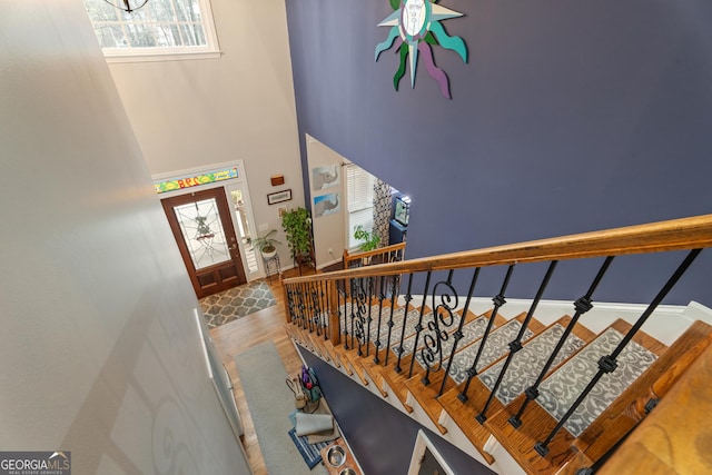 stairway featuring hardwood / wood-style floors and a towering ceiling