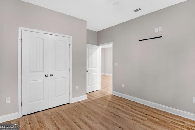 unfurnished bedroom featuring light hardwood / wood-style floors and a closet