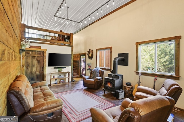 living room featuring a towering ceiling and a wood stove