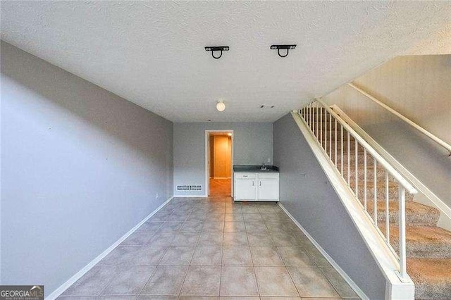 unfurnished living room with tile patterned floors and a textured ceiling