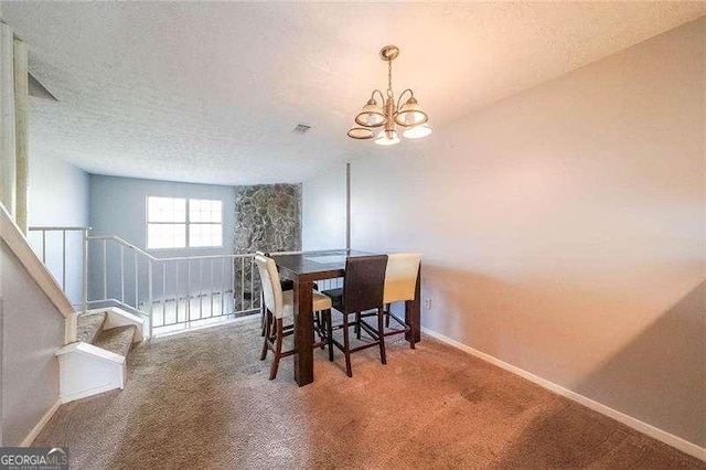 dining area featuring an inviting chandelier, carpet floors, and a textured ceiling