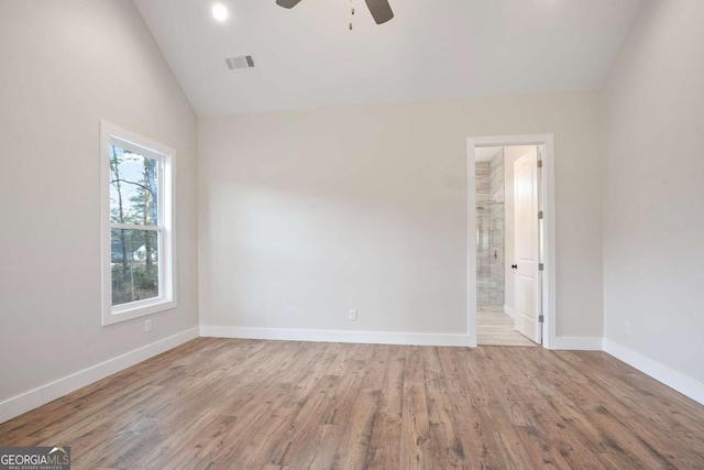 interior space with ensuite bathroom, lofted ceiling, ceiling fan, and light hardwood / wood-style flooring