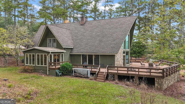 back of house with a deck, a shingled roof, a sunroom, a yard, and a chimney