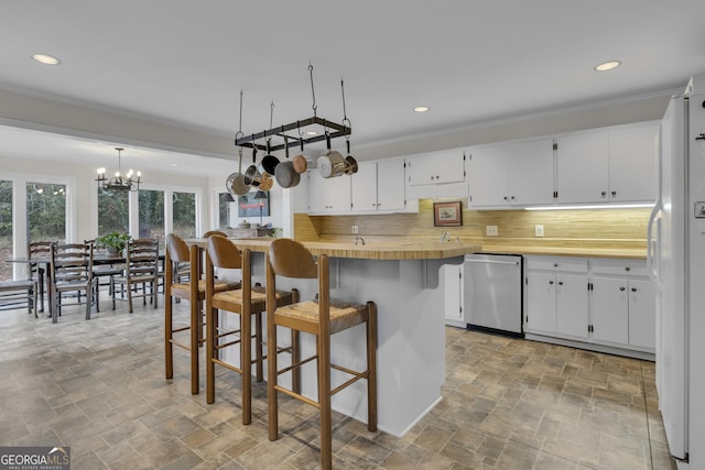 2724 Barnesville Hwy, Thomaston, GA 30286 - kitchen with stainless steel dishwasher, stone finish flooring, backsplash, freestanding refrigerator, and a kitchen bar