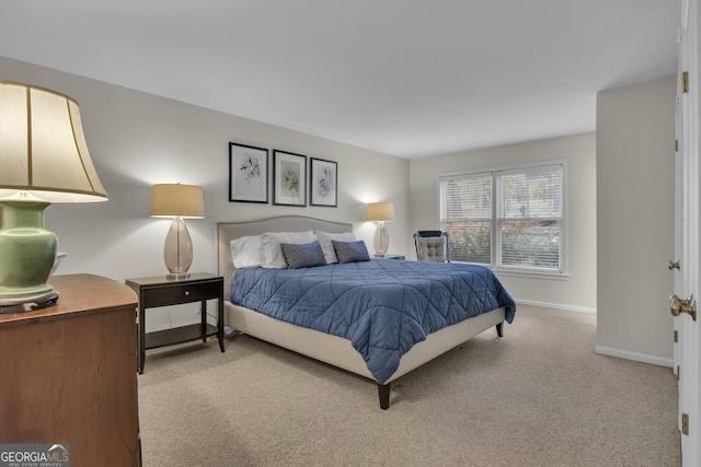 bedroom with light colored carpet and baseboards