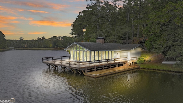 view of dock with a water view and a forest view