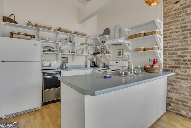 kitchen with white appliances, light wood-style flooring, and open shelves