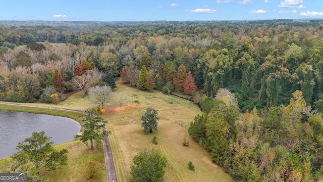 birds eye view of property with a water view and a wooded view