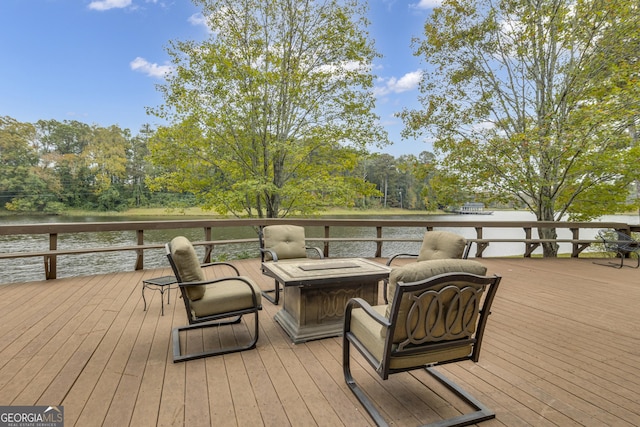 deck featuring an outdoor fire pit and a water view