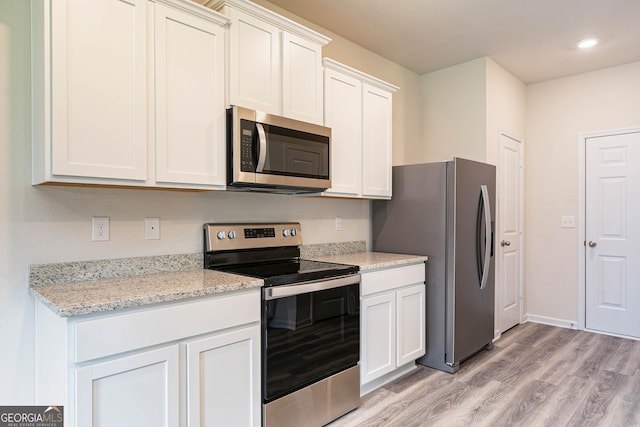 kitchen featuring light stone counters, light hardwood / wood-style flooring, stainless steel appliances, and white cabinets