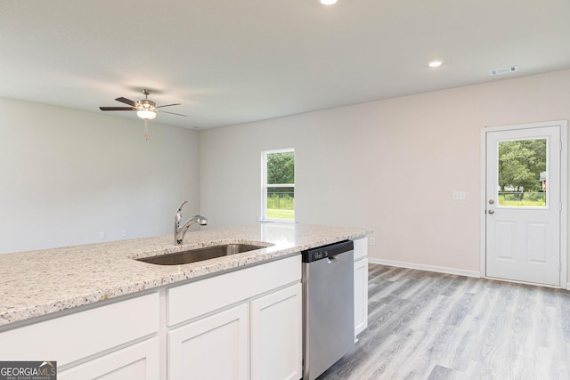 kitchen with sink, white cabinetry, light stone counters, stainless steel dishwasher, and light wood-type flooring