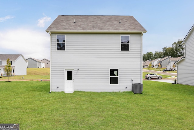 back of property with a lawn and central air condition unit