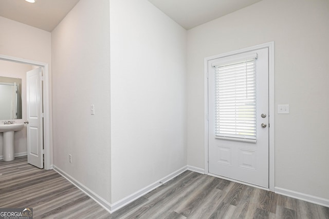 doorway to outside with hardwood / wood-style floors and sink