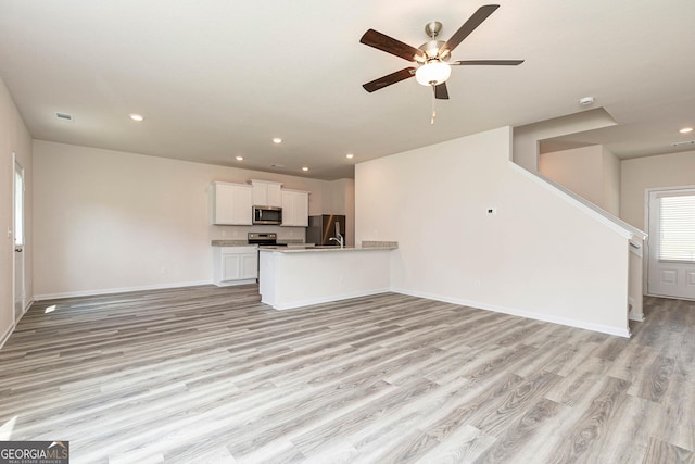 unfurnished living room featuring ceiling fan and light wood-type flooring