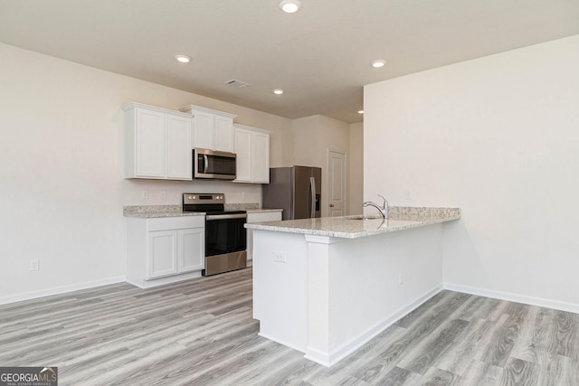 kitchen with white cabinetry, sink, light hardwood / wood-style floors, and appliances with stainless steel finishes