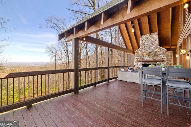 wooden deck featuring a stone fireplace