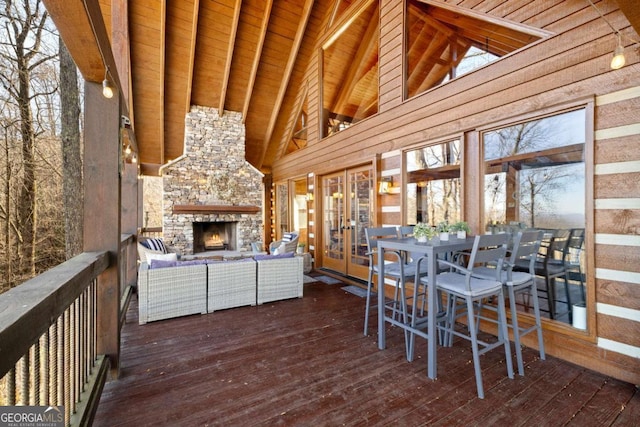 wooden terrace featuring french doors and an outdoor living space with a fireplace