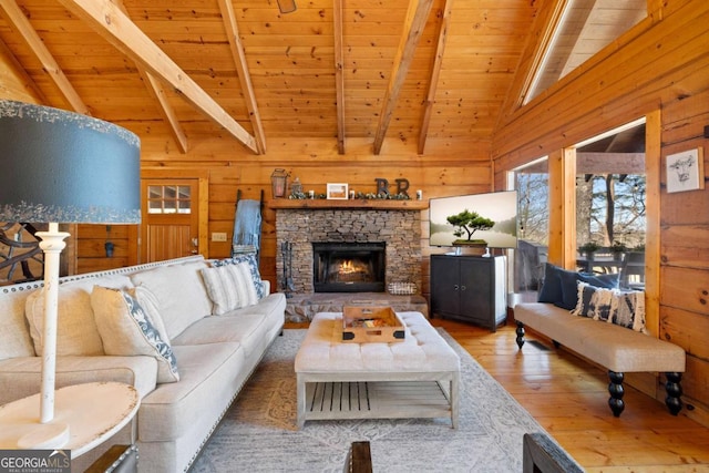 living room with vaulted ceiling with beams, wooden ceiling, wooden walls, hardwood / wood-style flooring, and a fireplace