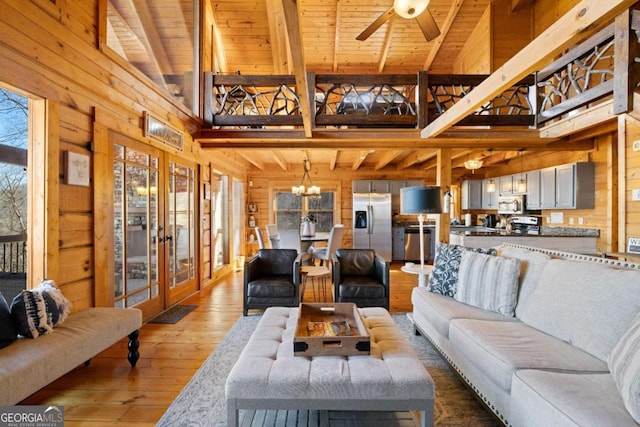 living room with wood ceiling, high vaulted ceiling, wooden walls, beamed ceiling, and hardwood / wood-style floors