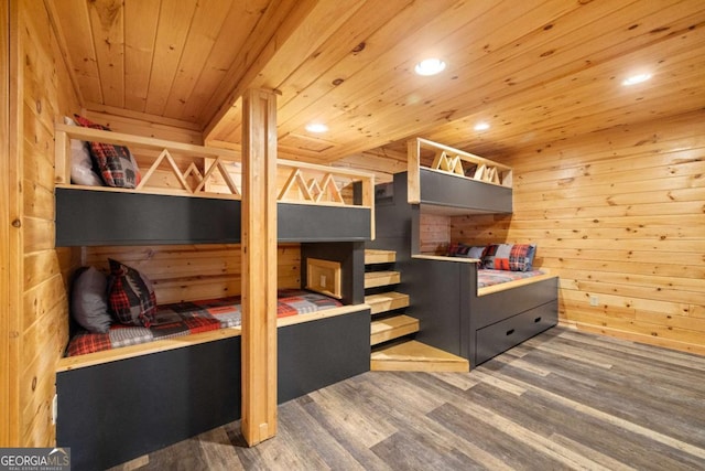 bedroom with hardwood / wood-style flooring, two closets, wooden ceiling, and wooden walls